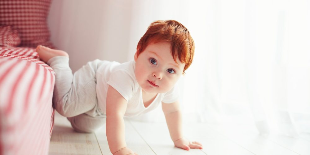 cute toddler baby getting off the bed, crawling at home